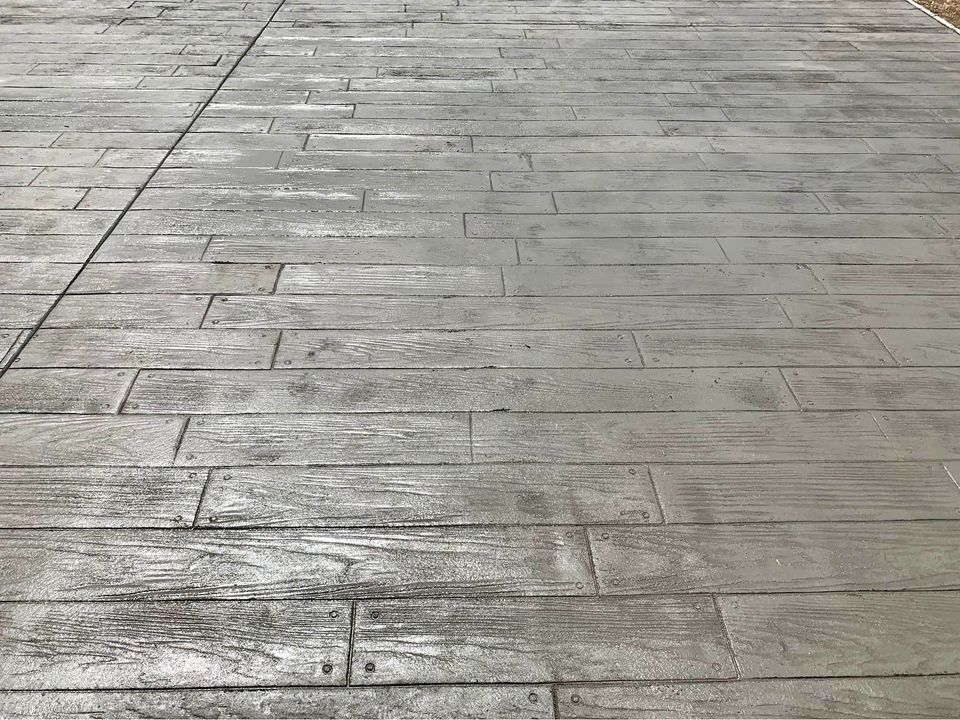 Concrete contractor in Albuquerque offers surfaces textured with a wood-like pattern, featuring parallel lines and rectangular segments for a convincing impression of a wooden plank floor. Get your free quote today!